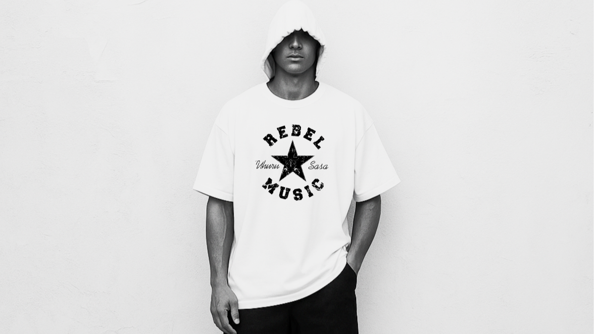 Model wearing the "Rebel Music" graphic tee from Two Souls Inc., standing against a gritty urban backdrop with bold street art and cracked pavement, capturing the spirit of underground sound, resistance, and streetwear rebellion.